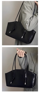 Detail of minimalist black patent leather shoulder bag with knotted strap and silver hardware
