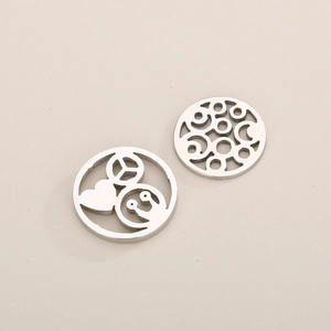 Detailed view of stainless steel round pendants with heart and peace sign hollow carvings