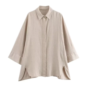 Dettaglio in piano di una camicia di lino beige chiaro con vestibilità ampia e spacchi