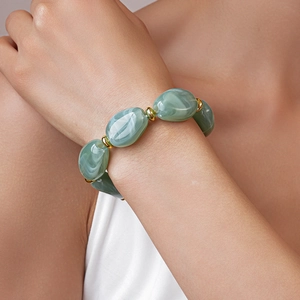 Close-up of green marble acrylic beads and gold metal spacers on a model's wrist
