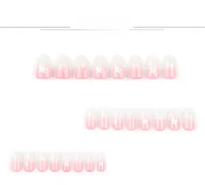 Detail view of pink and white gradient press-on nails featuring white star patterns