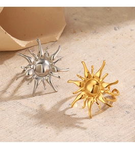 Detail of adjustable sunburst rings in gold and silver finish on textured stone