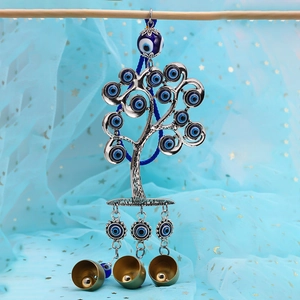Detailed view of silver tree of life evil eye pendant with blue beads and brass bells