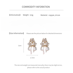 Vue détaillée des boucles d'oreilles fleurs et nœuds avec zircons et taille 3cm x 1.7cm
