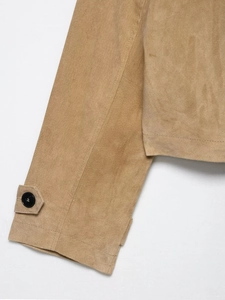 Detailed close-up of khaki faux suede jacket sleeve cuffs with button strap and stitching