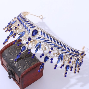 Luxurious gold baroque bridal crown with blue water-drop crystals on vintage wood box