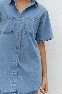 Detail of short sleeve denim dress with lapel collar and chest pockets in light blue