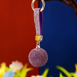 Detailed view of luxury purple rhinestone sphere keychain with matching leather strap