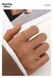 Chic golden ring with hollow heart-shaped links worn on finger for daily style