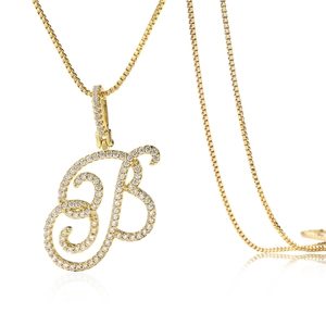 Gros plan sur la chaîne box dorée et pendentif lettre B en cursive avec oxydes