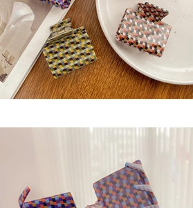 Detail view of various square acetate claw clips with retro checkered patterns and colors