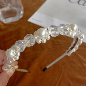Elegant headband with white pearls and clear faceted crystals on a metal base frame