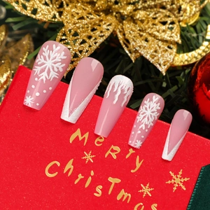 Set di unghie finte natalizie con fiocchi di neve 3D e punte glitterate su sfondo festivo