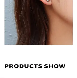 Close-up of geometric silver stud earrings with 3D faceted design on a female model