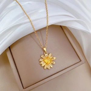 Close-up of champagne gold sunflower necklace with yellow gem in a jewelry gift box
