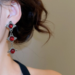 Close-up of vintage resin round drop earrings with dark silver finish on a model