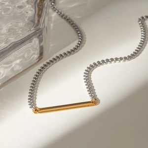 Two-tone stainless steel curb chain necklace with a minimalist gold bar pendant