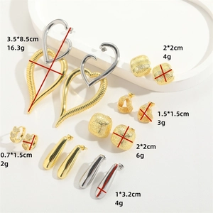 Chic gold and silver oversized heart earrings and geometric jewelry set on white background