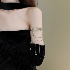 Detail shot of silver armlet with layered star charm chains and metallic fringe