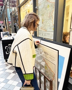 Quilted cropped jacket with green trim and beige padding shown in a gallery