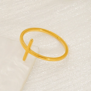 Minimalist gold cross open ring in polished stainless steel on white texture