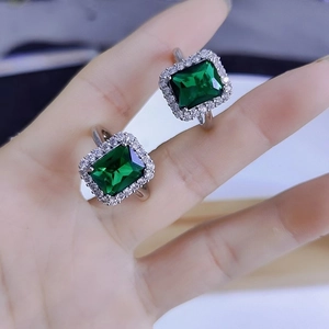 Luxe emerald geslepen ring met een fonkelende halo van witte stenen op een zilveren band