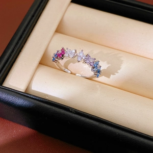 Detailed macro view of an adjustable silver ring with colorful zircons in a jewelry box