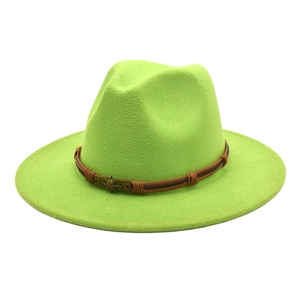 Detail of neon green wool fedora hat featuring a brown band and metal sun skull emblem