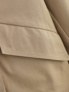 Detailed macro shot of khaki trench coat fabric with precision double stitching