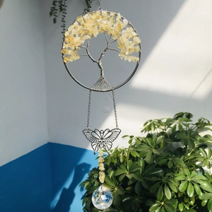 Detail of tree of life suncatcher with yellow crystals, metal butterfly and crystal ball