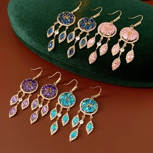 Detail view of vintage diamond-shaped tassel earrings in four elegant colors
