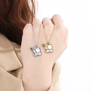 Detailed view of gold and silver elephant necklaces with shell inlay and small diamond eyes