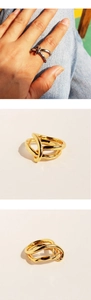 Detail shot of silver and gold double-layered knot rings with minimalist metallic texture