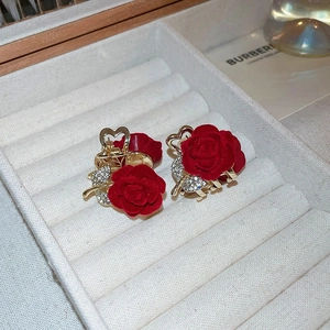 Close-up of elegant red flocked rose hair clips with gold metal and sparkling crystals