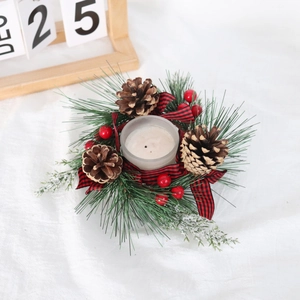 Christmas candle holder with pine needles, cones, red berries and plaid bow on white