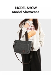 Detail of grey canvas tote bag with brown straps and vintage leather logo patch
