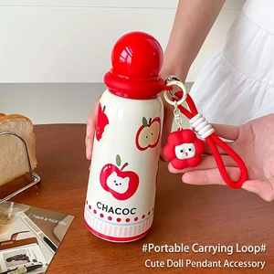 Cute cartoon vacuum flask with red cat pattern and flower keychain on wooden table