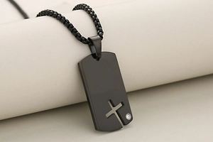 Détail d'un collier plaque militaire noir mat avec croix ajourée et petit zircon serti