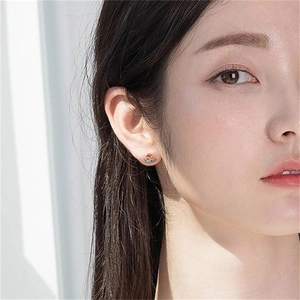 Close-up of a model wearing a creative watermelon slice stud earring in vibrant colors