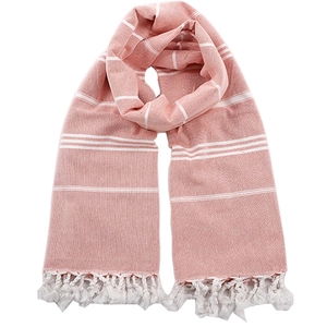Detail of pink striped cotton beach towel with delicate white tassels and soft texture