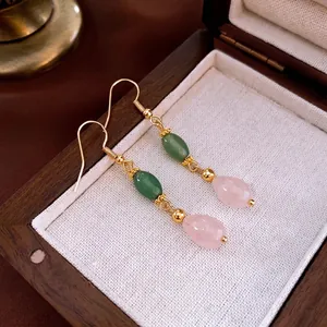 Vintage teardrop earrings with green jade beads and pink quartz stones on wood box