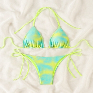 Detailed flat lay of tie-dye yellow and blue string bikini set on white fabric