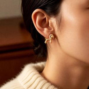 Close-up of a 18k gold plated balloon horse earring with sparkling zircons on a model