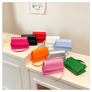 Multiple colors of minimalist crossbody bags displayed on a white step in a cafe setting