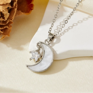 Détail du collier lune argenté avec nacre et pendentif en forme d'étoile en zircon