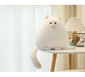 Close-up of fluffy white Persian cat plush toy on table in warm home setting