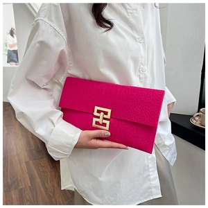 Close-up of rose red felt clutch bag with golden buckle held by a model in white