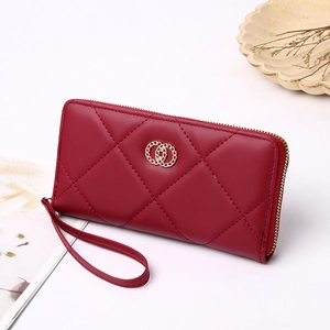 Detail of red quilted long wallet with golden double-ring clasp and wrist strap