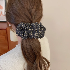 Gros plan détaillé d'un grand chouchou à motif léopard porté dans les cheveux