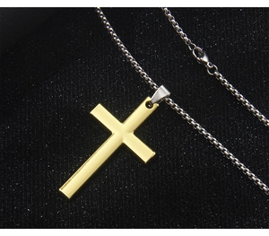 Detailed close-up of a golden cross pendant on a silver metal chain over a black background